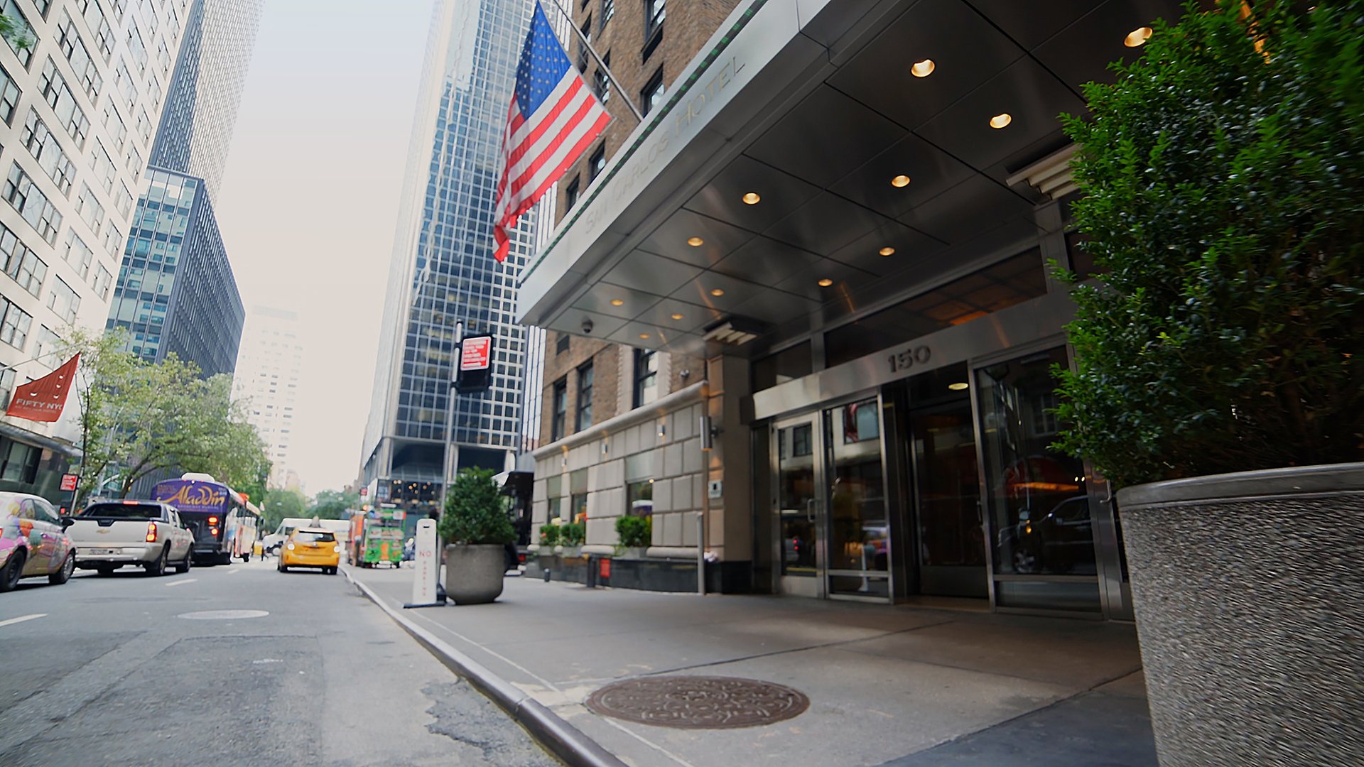 The exterior of a building with a glass door entrance, an awning, and an American flag.