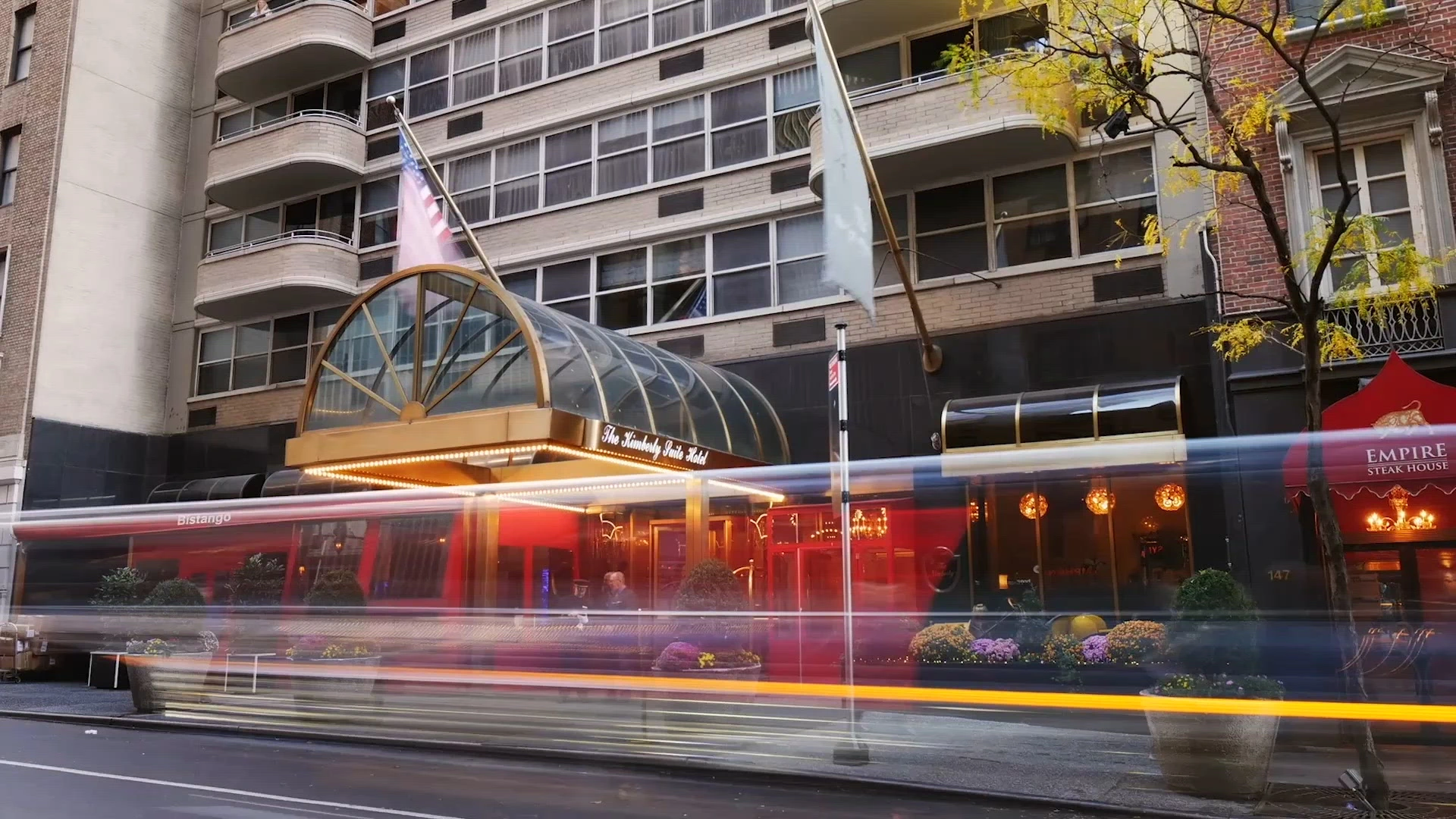 A photo of a city street with a bus stop and a building in the background.